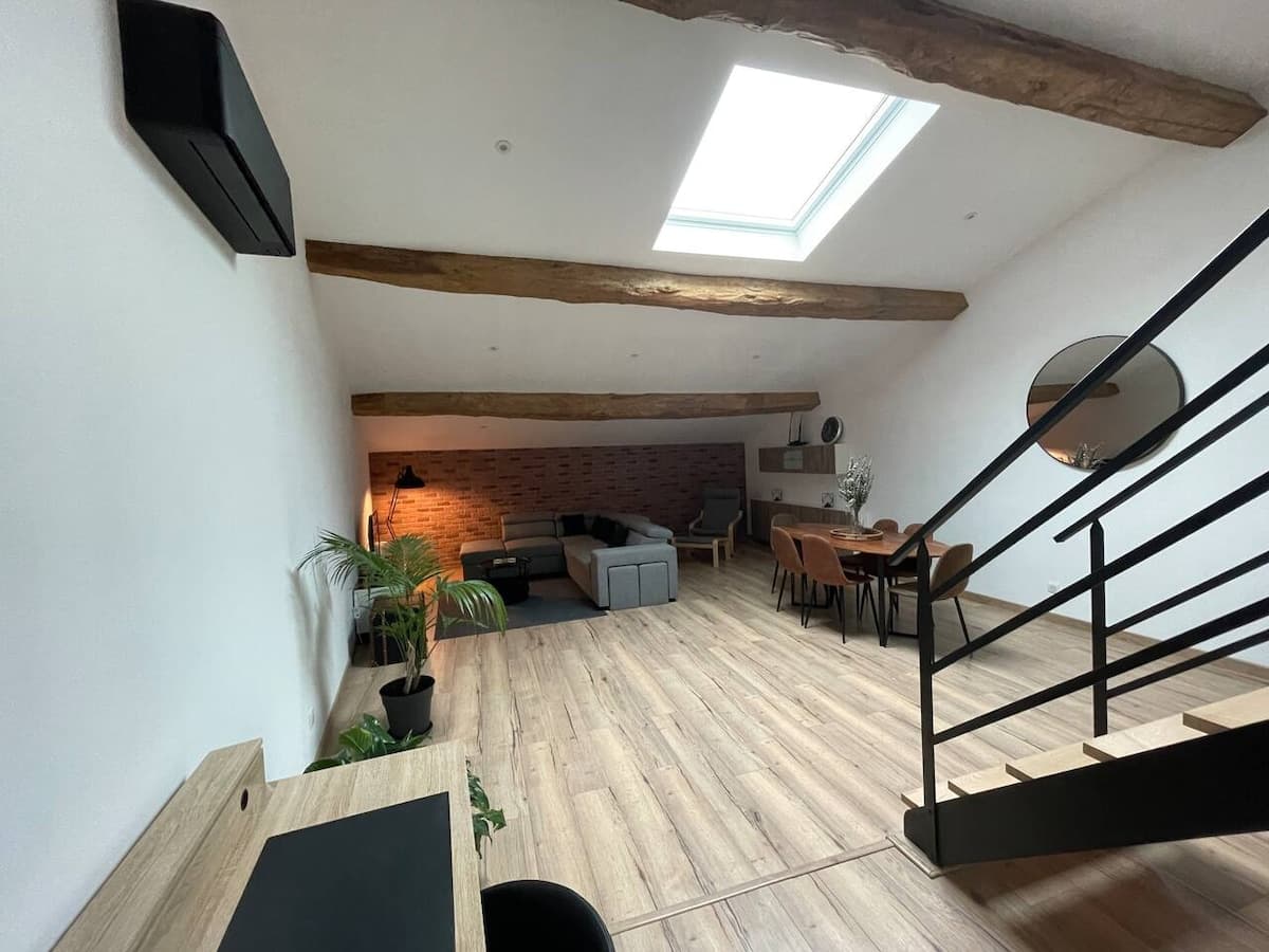 La pièce de vie vue depuis le coin bureau, sous le Velux et les poutres